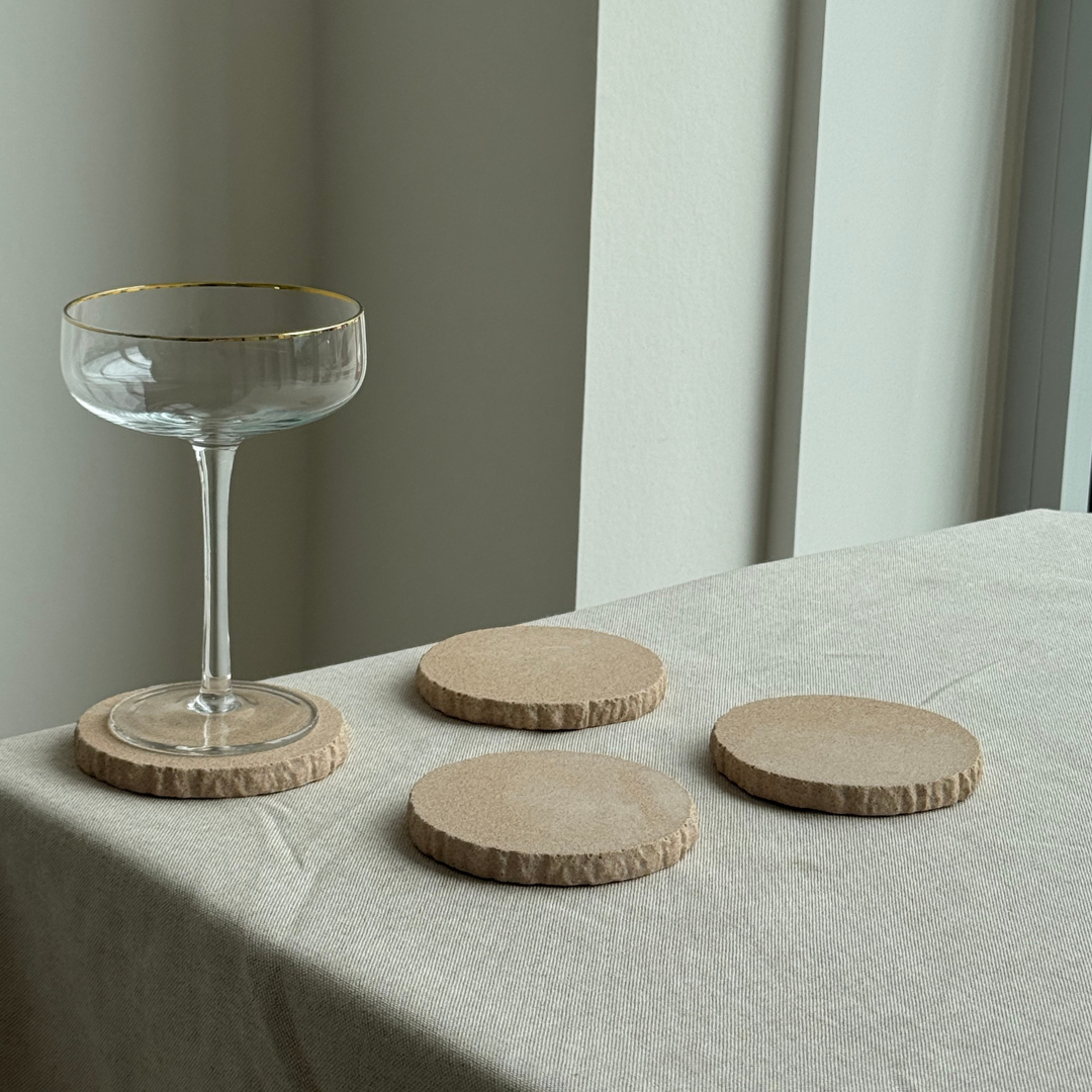 hand-poured micro concrete coasters, modern almond beige stone-look finish, minimalist drink coasters, functional and stylish drink accessories, high-quality concrete home decor, eco-friendly coaster set, contemporary table decor, unique coasters for home, sustainable coasters for drinks, premium concrete drinkware, handmade coasters for dining or living room, versatile coaster set for glass, mug, or cup, perfect gift for home decor lovers, elegant and durable home accessories, ginaladeco