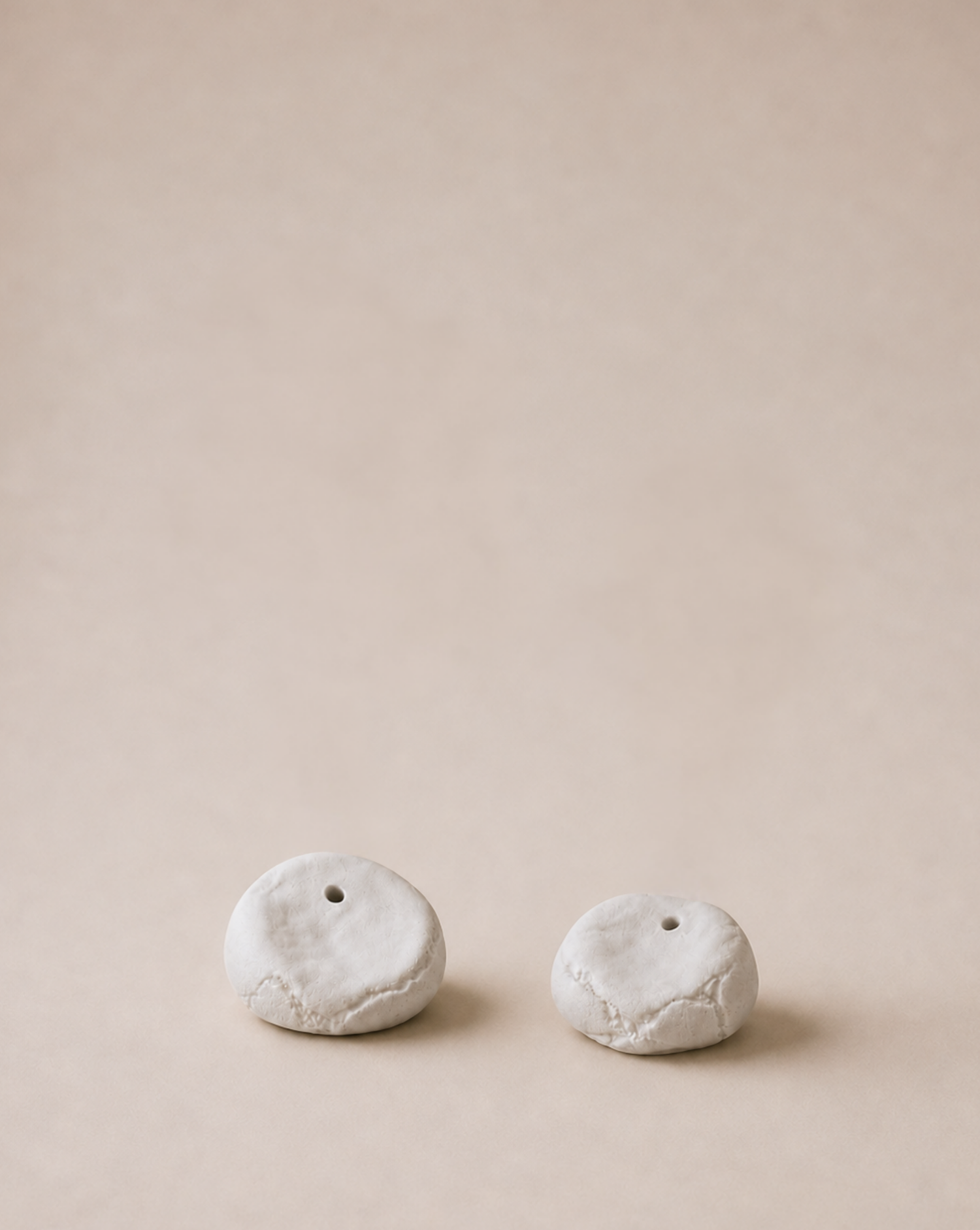 minimalist interior, white roses, ceramic vases, handmade decor, pebble vases, sculptural objects, wooden shelf, window light, sunlight shadows, neutral tones, aesthetic decor, soft natural light, floral arrangement, modern home, calm atmosphere, windowsill styling, organic shapes, artisanal pottery, natural materials, simple living, serene space, cozy corner, contemporary design, clean aesthetic, still life, home styling