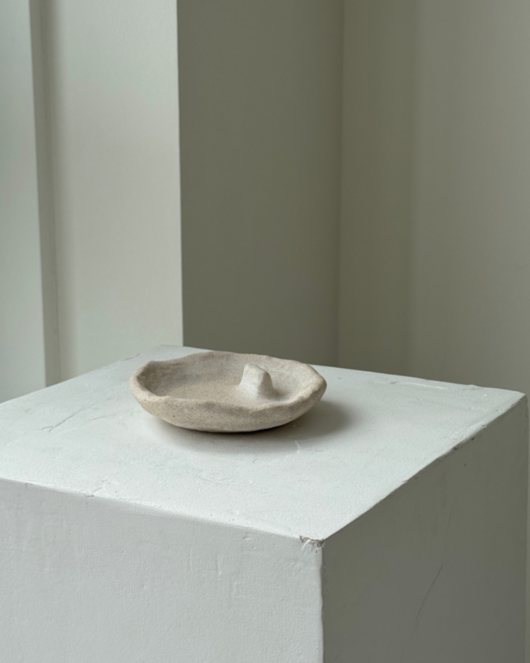 hand-poured micro concrete palo santo dish, modern stone-look finish, minimalist decor for palo santo burning, functional and sculptural home decor, almond beige color, elevated rest for palo santo stick, eco-friendly concrete dish, unique incense holder, contemporary decor for living room or meditation space, high-quality concrete home accessory, handmade dish for spiritual practices, versatile decorative object, premium concrete art piece, stylish and functional gift for wellness lovers, ginaladeco