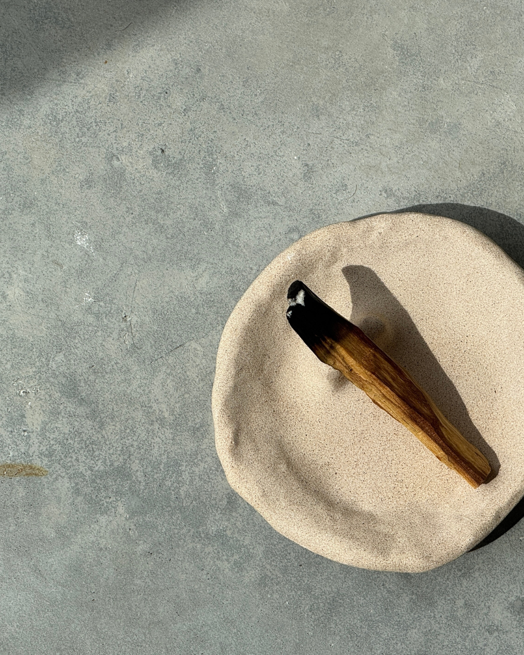 hand-poured micro concrete palo santo dish, modern stone-look finish, minimalist decor for palo santo burning, functional and sculptural home decor, almond beige color, elevated rest for palo santo stick, eco-friendly concrete dish, unique incense holder, contemporary decor for living room or meditation space, high-quality concrete home accessory, handmade dish for spiritual practices, versatile decorative object, premium concrete art piece, stylish and functional gift for wellness lovers, ginaladeco