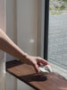 minimalist interior, white roses, ceramic vases, handmade decor, pebble vases, sculptural objects, wooden shelf, window light, sunlight shadows, neutral tones, aesthetic decor, soft natural light, floral arrangement, modern home, calm atmosphere, windowsill styling, organic shapes, artisanal pottery, natural materials, simple living, serene space, cozy corner, contemporary design, clean aesthetic, still life, home styling